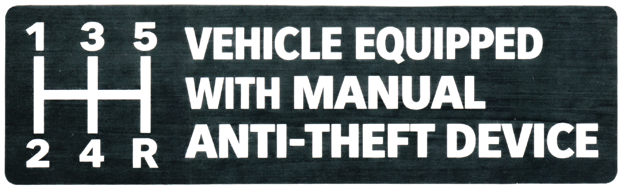 black bumper sticker with white text reading 'VEHICLE EQUIPPED WITH MANUAL ANTI-THEFT DEVICE' next to a white illustration of a manual transmission shift pattern